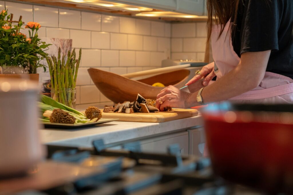 An adult shopping vegetables at a chopping board with asparagus in the background